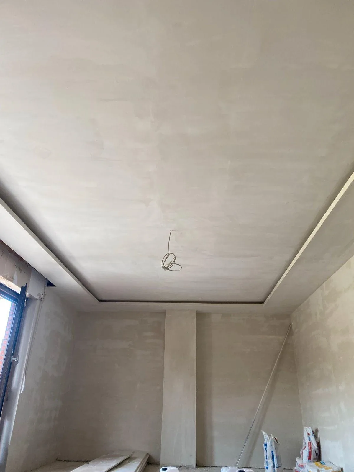 Abgehängte Trockenbaudecke mit umlaufendem Randdetail in einem Raum im Ausbau